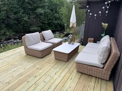two chairs and a table on a wooden deck at Gjestehus i Hurdal uten innlagt vann Delt bad in Hurdal