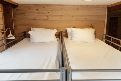 two beds in a room with wooden walls at Family-friendly Cabin with pier - Herdla to Bergen - 40 min in Herlø