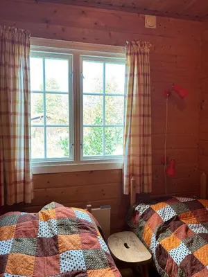 a bedroom with two beds and a window at Geilo - Hyggelig og sentral hytte in Hol