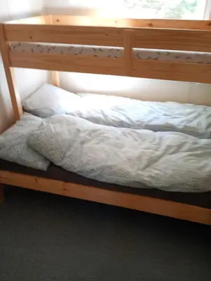 a wooden bunk bed with white sheets on it at Gullingen Cabin Winter Wonderland