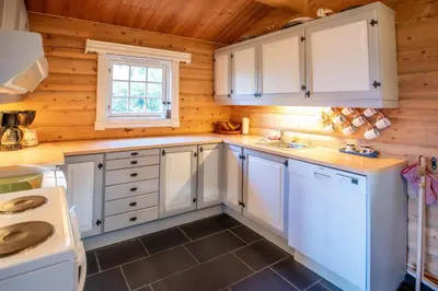 a kitchen with white cabinets and a window at Trysilfjellet Sør 480 in Trysil