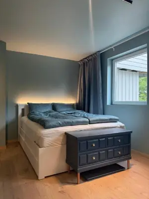 a bedroom with a large bed with a window at Moderne leilighet in Bergen