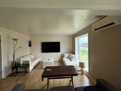 a living room with a couch and a tv at Et hus dypt i havet in Steinshamn