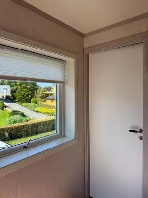 a window in a room with a roller blind at Et hus dypt i havet in Steinshamn