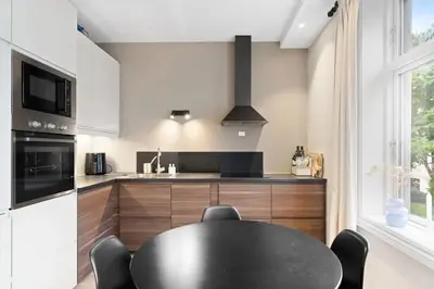 a kitchen with a black table and chairs in a room at Inviting & Cozy City Apartment in Bergen