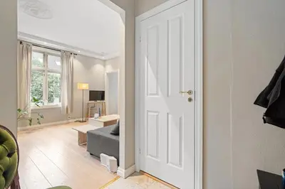 a white door leading to a living room with a couch at Inviting & Cozy City Apartment in Bergen