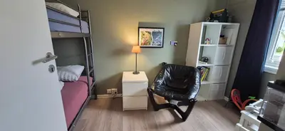 a small bedroom with a bunk bed and a chair at Central Langevåg Family Apartment in Sula