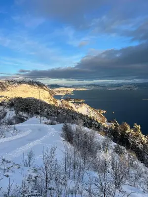 a snowy hill with a view of a body of water at Haus Harald in Tysnes