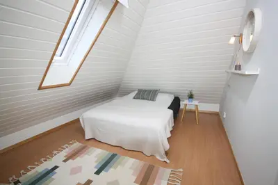a small attic bedroom with a bed and a window at Cozy apartment - central! in Bergen