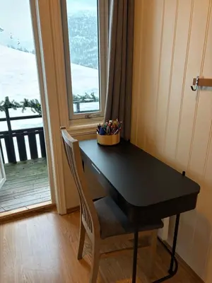a black desk with a chair and a window at Apartment vårstølen in Vossevangen