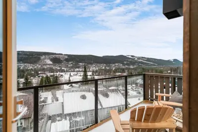 a balcony with chairs and a view of the mountains at Motoppen Trysil Apartments in Trysil