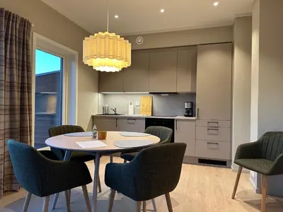 a kitchen and dining room with a table and chairs at Motoppen Trysil Apartments in Trysil