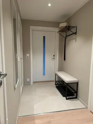a hallway with a door with a bench next to it at Motoppen Trysil Apartments in Trysil