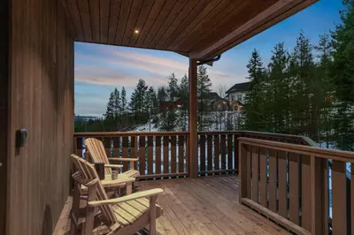two chairs on a deck with a view of the mountains at Motoppen Trysil Apartments in Trysil