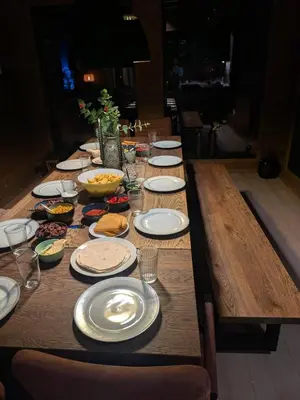 a long wooden table with plates of food on it at 2 cabins surrounded by beautiful nature in Stryn