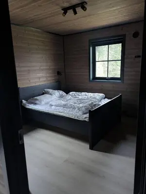 a large bed in a room with a window at 2 cabins surrounded by beautiful nature in Stryn