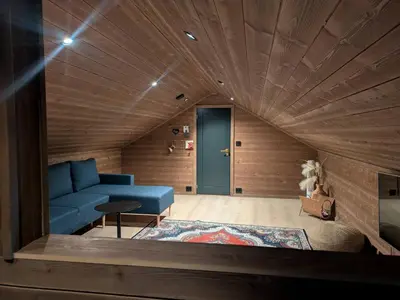 a living room with a blue couch and a wooden ceiling at 2 cabins surrounded by beautiful nature in Stryn