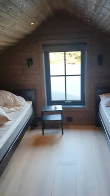 a small room with two beds and a window at 2 cabins surrounded by beautiful nature in Stryn