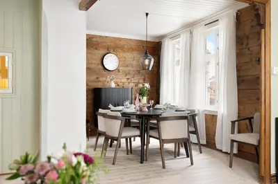 a dining room with a table and chairs and a clock at Historic Gem I Charming Bergen Home in Bergen