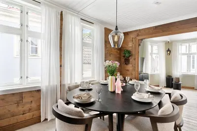 a dining room with a table and chairs and windows at Historic Gem I Charming Bergen Home in Bergen