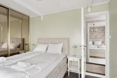 a bedroom with a large bed and a mirror at Historic Gem I Charming Bergen Home in Bergen