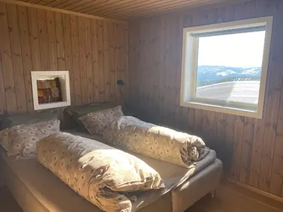 a bedroom with a bed with pillows and a window at Blefjell hytte med fantastisk utsikt in Kongsberg