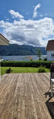 a wooden deck with a view of the water at Hus ved sjøen, med strand og naust in Sauda