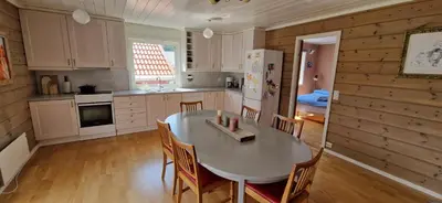 a kitchen with a table and chairs in a room at Hus ved sjøen, med strand og naust in Sauda