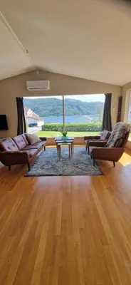 a living room with two couches and a table at Hus ved sjøen, med strand og naust in Sauda