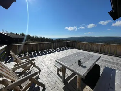 a wooden deck with a picnic table and chairs at Annebu by Norgesbooking - cabin at 1000 meter with amazing view in Ål