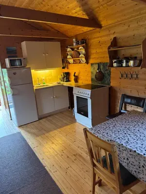 a kitchen with a table and a white refrigerator at Sjøbakken Fjord Camping AS in Sykkylven