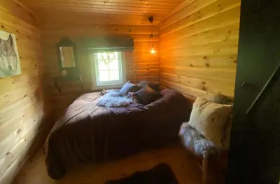 a bedroom with a bed in a log cabin at Hytte med panoramautsikt i Uvdal in Nørdstebø