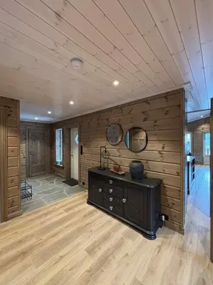 a large room with a wooden wall with a table in it at Fjellhytte sentralt og solrikt in Stryn