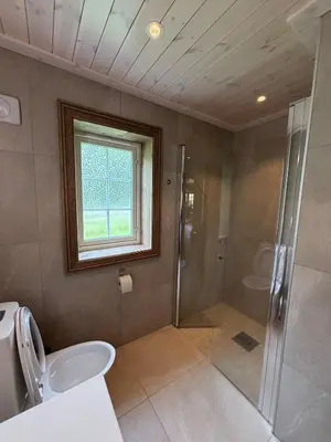 a bathroom with a shower and a toilet and a sink at Fjellhytte sentralt og solrikt in Stryn