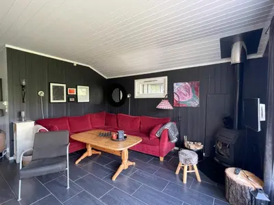a living room with a red couch and a table at Revehiet - 3 bedroom cabin in the center of Geilo in Geilo