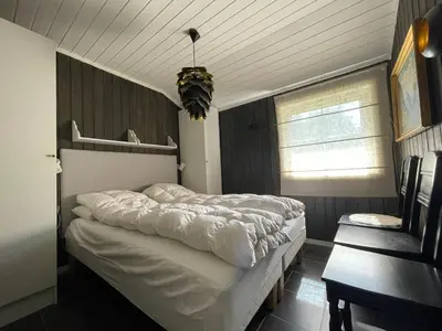 a bedroom with a large bed and a window at Revehiet - 3 bedroom cabin in the center of Geilo in Geilo