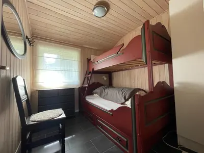 a small room with a bunk bed and a chair at Revehiet - 3 bedroom cabin in the center of Geilo in Geilo