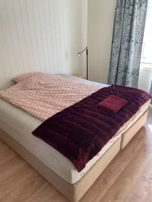 a bed with a purple blanket on top of it at Best flat in town in Kristiansund