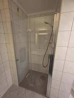 a shower with a glass door in a bathroom at Best flat in town in Kristiansund