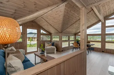 an open living room with a large wooden ceiling at Hedda Robølshøvda - 3 bedroom cabin with a lovely view in Heggenes