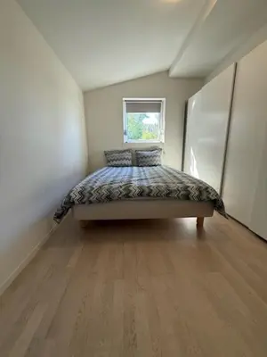 a bedroom with a bed in a room with a window at Home with 5 bedrooms, great view and garden in Bergen
