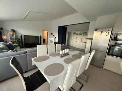 a dining room with a table and chairs and a couch at Home with 5 bedrooms, great view and garden in Bergen