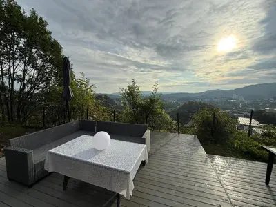 a white table sitting on top of a wooden deck at Home with 5 bedrooms, great view and garden in Bergen
