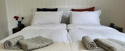 two white pillows and towels on a bed at Free EV Charging with Snacks and View in Blesom