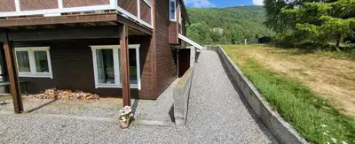 a brown house with a dog laying outside of it at Free EV Charging with Snacks and View in Blesom