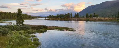 a view of a river with trees and mountains at Free EV Charging with Snacks and View in Blesom