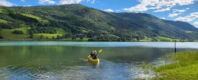 a person in a kayak in the middle of a lake at Free EV Charging with Snacks and View in Blesom