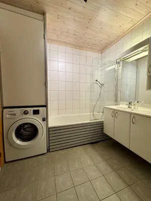 a bathroom with a washing machine and a tub at Fantastisk utsikt i Hemsedal med ski in og ski ut in Fausko