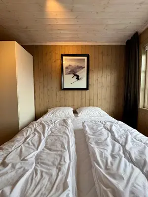 a bed in a room with a picture on the wall at Fantastisk utsikt i Hemsedal med ski in og ski ut in Fausko