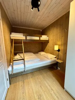 a bedroom with a bunk bed in a wooden room at Fantastisk utsikt i Hemsedal med ski in og ski ut in Fausko
